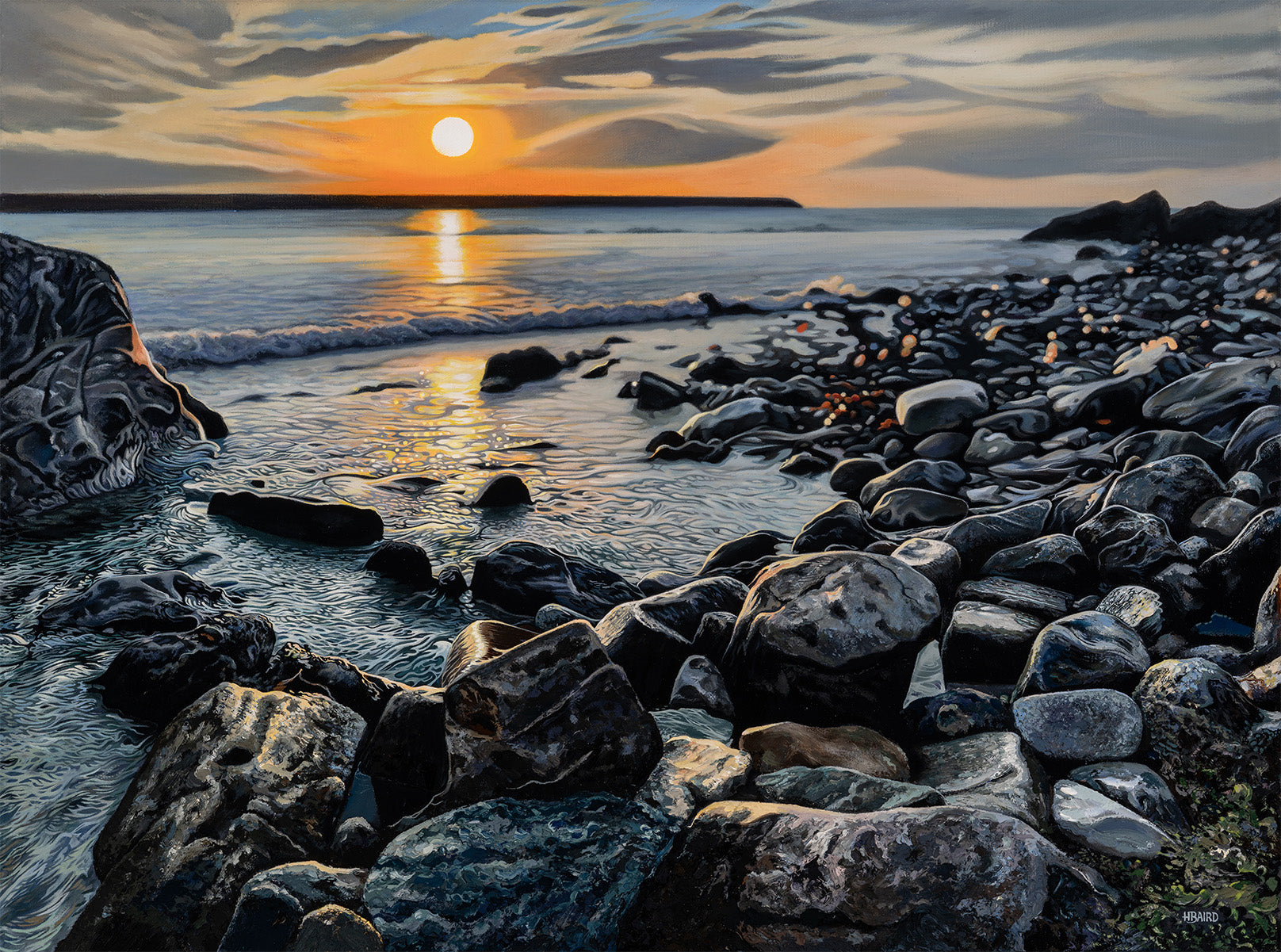 Sunset over a rocky beach with calm water and scattered rocks.